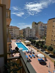 a view of a swimming pool with chairs and umbrellas at Cozy apartment near Los Boliches Beach in Fuengirola