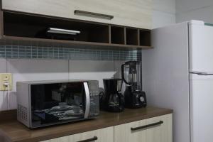 a microwave sitting on a counter in a kitchen at Studio Casa Amarela - a 400m do Corredor Cultural in Mossoró