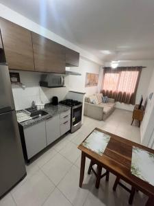 eine Küche und ein Wohnzimmer mit einem Tisch und einem Kühlschrank in der Unterkunft Apartamento em São Paulo in São Paulo