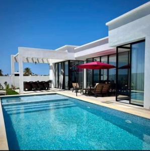 - une piscine en face d'une maison dans l'établissement villa Casa Luxe djerba, à Mezraya