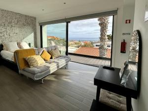 a living room with a couch and a view of the ocean at A Casa do Góis - Villa in Porto Santo in Porto Santo