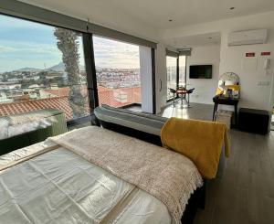 a bedroom with a bed and a large window at A Casa do Góis - Villa in Porto Santo in Porto Santo