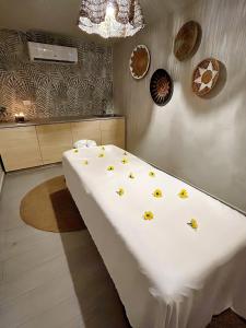 - un grand lit blanc orné de fleurs jaunes dans l'établissement Bali Poshtel PR, à San Juan
