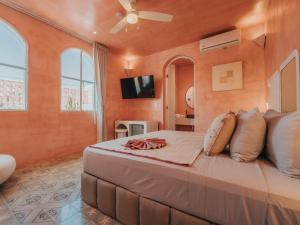 a bedroom with a large bed with a ceiling fan at Casa Amate 61 - Mérida centro in Mérida