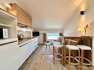 eine Küche mit weißen Schränken und Barhockern in der Unterkunft Deluxe Villa No.10 - Rooms & Apartments in Mandre