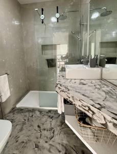 a bathroom with a sink and a shower and a tub at A Casa do Góis - Villa in Porto Santo in Porto Santo
