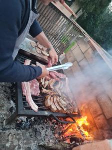 a person is cooking meat on a grill at Agriturismo IL Paradiso di Berignone in Caprareccia