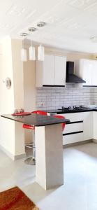 a kitchen with white cabinets and a black counter top at Summer Homes Bungoma in Bungoma