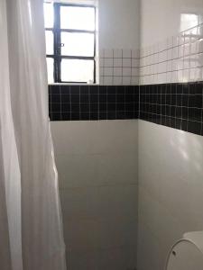 baño con ducha, aseo y ventana en Summer Homes Bungoma, en Bungoma