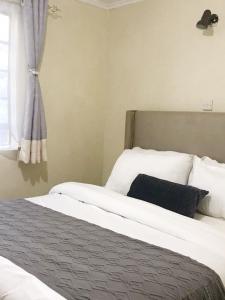 1 dormitorio con cama y ventana en Summer Homes Bungoma, en Bungoma