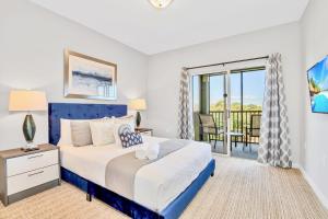 a bedroom with a blue bed and a balcony at 3BR Condo - Games Hot Tub Sauna - Near Disney in Orlando