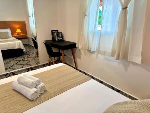 um quarto com uma cama e uma secretária com toalhas em 15 min Aeroporto Internacional de Guarulhos, 10 min centro GRU em Guarulhos