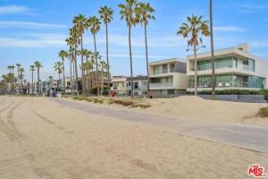 a sandy beach with palm trees and a building at 1BD Modern Venice Beach 12A in Los Angeles
