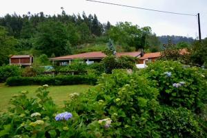 una casa en una colina con un patio con flores en Quinta de São Martinho - Visconde do Penedo, en Caniçada