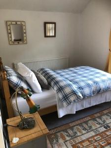 a bedroom with a bed and a table with a lamp at Plumtree Cottage in Cotgrave