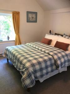 a bedroom with a bed and a window at Plumtree Cottage in Cotgrave