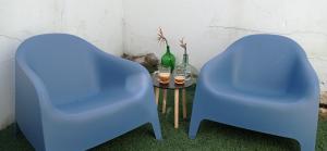 dos sillas azules sentadas junto a una mesa con bebidas en Apartamento con vistas en el Camino de Santiago Y Playa a 750 m, en Camposancos