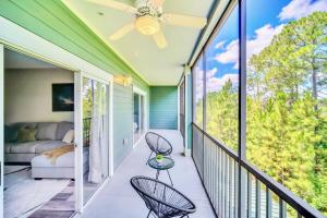een veranda met een bank en stoelen op een balkon bij Modern 2BR Condo - Hot Tub and Pool - Near Disney in Orlando