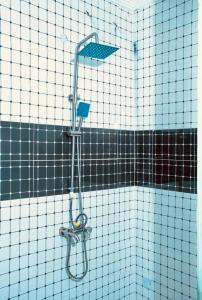 a shower in a bathroom with a tile wall at Executive Gold Hotel in Abuja
