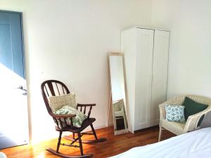 a bedroom with two rocking chairs and a mirror at 海之恋 in Arazato