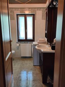 La salle de bains est pourvue d'un lavabo, de toilettes et d'une fenêtre. dans l'établissement Haisle im Untrborkh, à Sauris