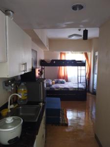 a kitchen with a sink and a bedroom with a bunk bed at Sunvida Tower Condominium in Cebu City
