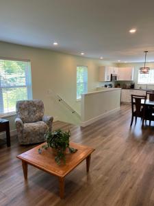 a living room with a table and a kitchen at Wellington House in Nanaimo