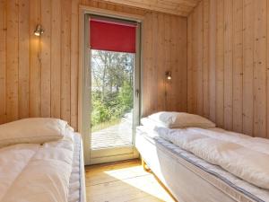 2 camas en una habitación con ventana en Splendid Holiday Home in Hadsund with Sauna, en Øster Hurup