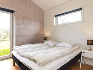 Sønder HurupにあるHoliday Home Hedegaarde IIの窓付きの客室で、白い大型ベッド1台が備わります。