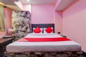 - une chambre avec un grand lit et des oreillers rouges dans l'établissement OYO Flagship Kirtiraj Lodging and Boarding, à Mumbai