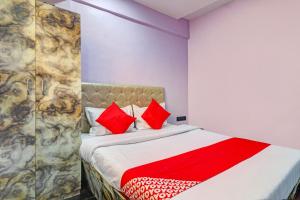 - une chambre avec un lit et des oreillers rouges dans l'établissement OYO Flagship Kirtiraj Lodging and Boarding, à Mumbai