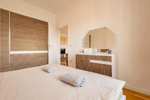 a bedroom with a white bed and a mirror at Apartment 5 in Pristina