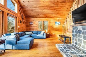 a living room with a blue couch and a fireplace at Gorgeous Chalet! VIEWS! Hot Tub! Sleeps 12! Games in Bethel