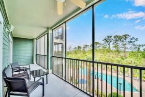 a balcony with chairs and a view of a pool at Bright 2BR Condo with Pool and Hot tub - near Disney! in Orlando