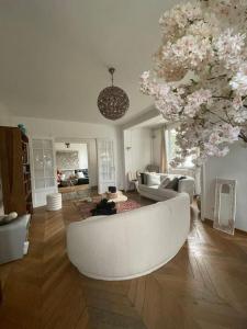 una sala de estar con un sofá blanco y flores en Maison 20 min de PARIS 
