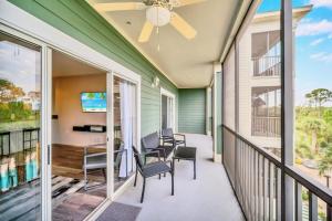 a balcony with chairs and a table and a tv at Bright 2BR Condo with Pool and Hot tub - near Disney! in Orlando