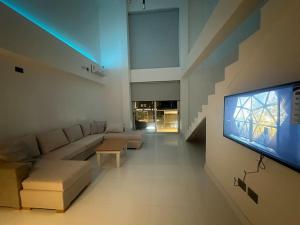 un soggiorno con divano e TV a schermo piatto di Departamento tipo loft! a Villa Zorraquín