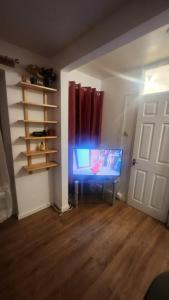 a room with a flat screen tv in a room at Gold Lodge in London