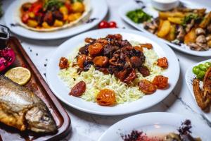 een tafel vol borden met voedsel met vlees en groenten bij New View Beach Hotel and Resort Lekki Lagos in Lagos