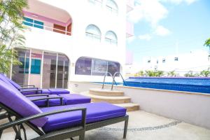a row of purple lounge chairs on the balcony of a building at Hotel Kavia in Canc&uacute;n