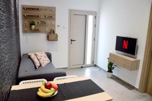 a living room with a couch and a table with fruit on it at Topikos Apartments in Ayia Napa