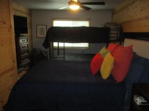 a bedroom with a bed with red and yellow pillows at SEWARD APARTMENT in Seward