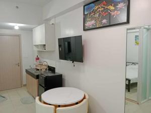 a small kitchen with a counter and a tv on the wall at MJC's Stay and Relax in Marilao