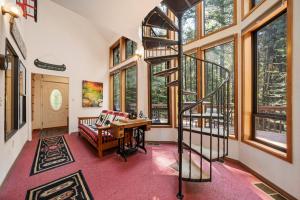 a living room with a spiral staircase and windows at Relaxing 2BD Cabin in the Sierra in Pioneer