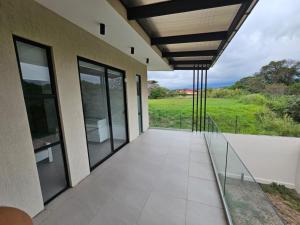 a balcony with glass doors and a view of a field at CASA SAN JOSE in San José