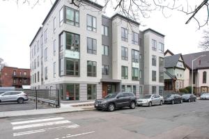 un gran edificio blanco con coches estacionados frente a él en Central Sq 3BR w WD nr MIT Kendall Sq BOS-367 en Cambridge