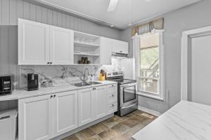 uma cozinha com armários brancos e um lavatório em Stylish 2bd, DT, Lndry & Prkng em Windsor