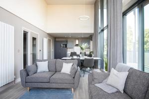 een woonkamer met 2 banken en een eetkamer bij Skyline Serenity: Exquisite 3-Bedroom Ultra-Luxury Penthouse in Belfast