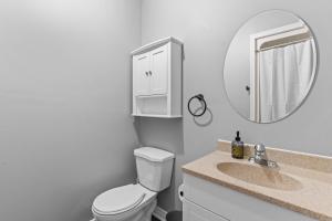 uma casa de banho com um WC, um lavatório e um espelho. em Stylish 2bd, DT, Lndry & Prkng em Windsor