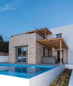 a villa with a swimming pool in front of a house at Vilianna in Zefiría